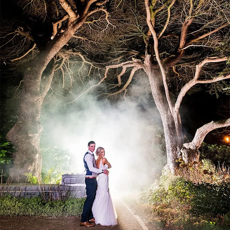 A bride and groom stand infront of a white steam backdrop at Clontarf Castle Wedding Venue in Dublin.