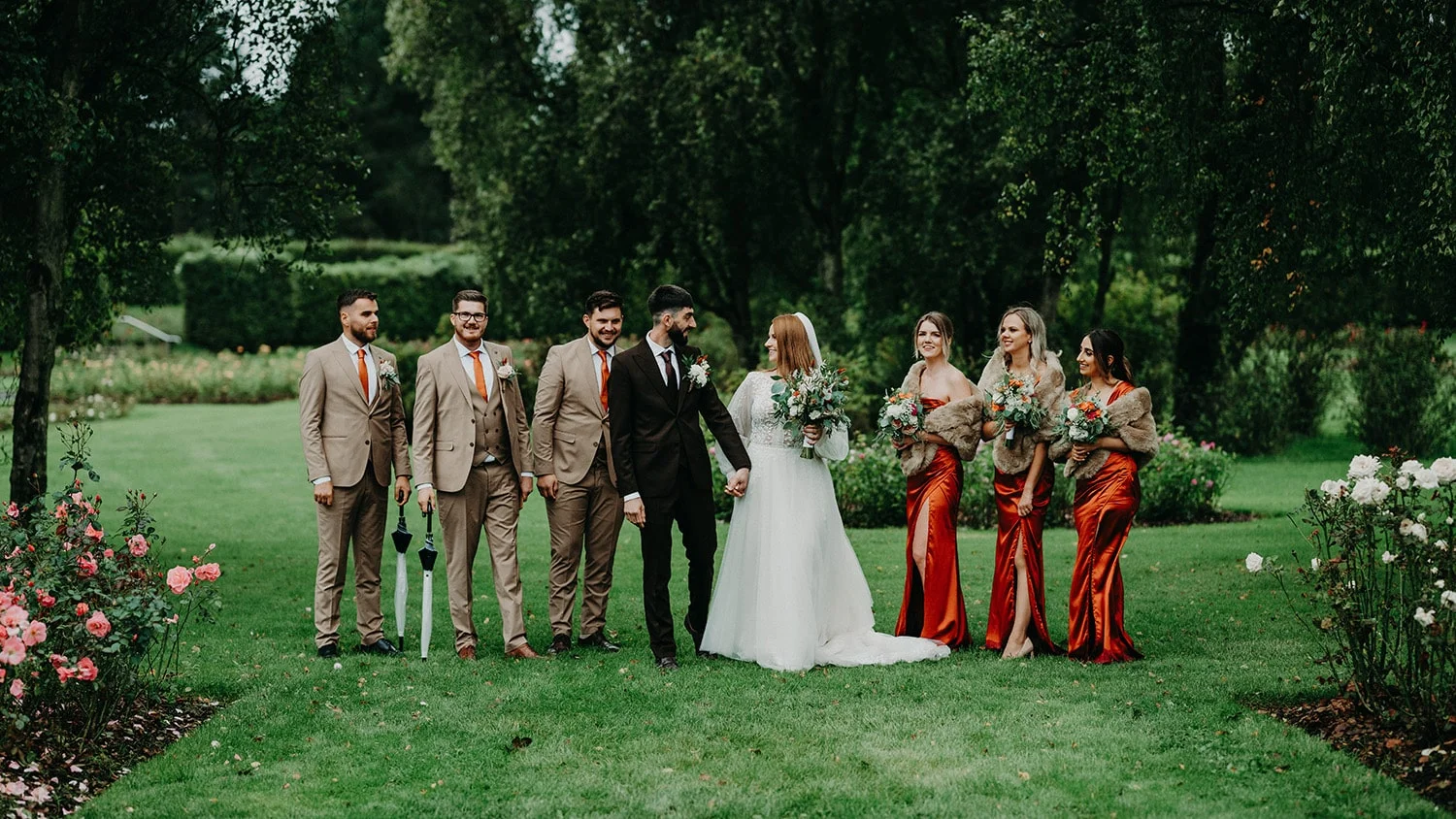 The wedding party gather around the bride and grrom in the Rose Garden at St. Anne's Park